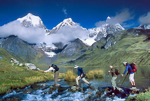 Trekkers cross the outlet stream of Lake Carhuacocha (13,600 feet) in the Cordillera Huayhuash, Peru, South America.