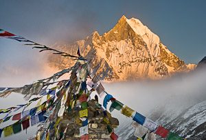 Machhapuchhre (or Machhapuchhare), the Fish Tail Mountain (22,943 feet / 6997 meters elevation) is a sacred peak, illegal to climb, in the Annapurna mountains (part of the Himalaya range), in Nepal. Tibetan Buddhist prayer flags fly from a monument at Ann