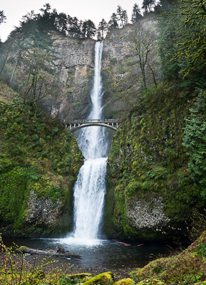 Multnomah Falls plunges 620 feet in two tiers in Columbia River Gorge National Scenic Area, adjacent to Interstate 84 and Historic Columbia River Highway, in Oregon, USA. A foot trail leads to Benson Footbridge, a 45-foot (14 m) long footbridge that allow